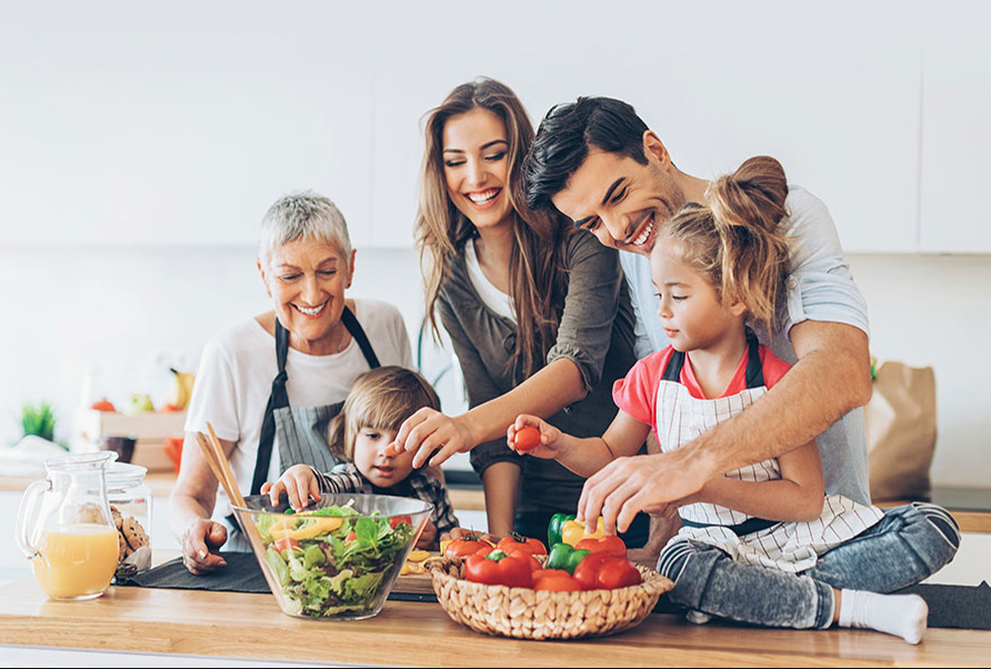 A cheerful family sitting in a kitchen table, preparing a colorful, balanced meal with fresh fruits and vegetables, emphasizing healthy eating habits for children.